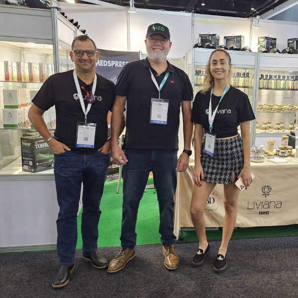 3 people standing in front of their stall displaying food products