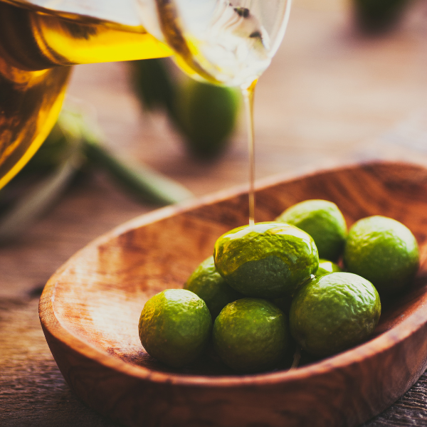 Olive oil pouring over olives